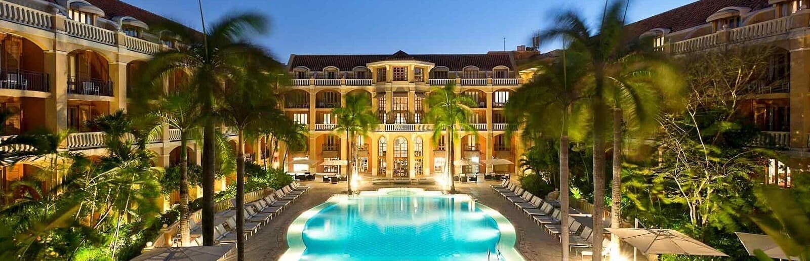 Sofitel Cartagena Santa Clara hotel courtyard with palms, pool, and warm-lit colonial architecture
