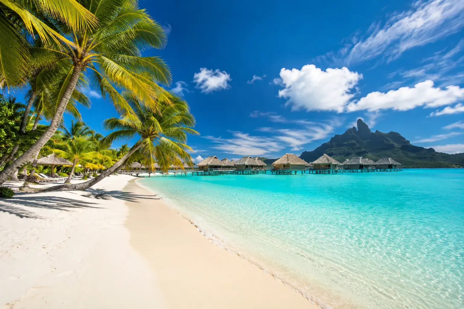 Overwater bungalows in Bora Bora with Mount Otemanu rising in the background