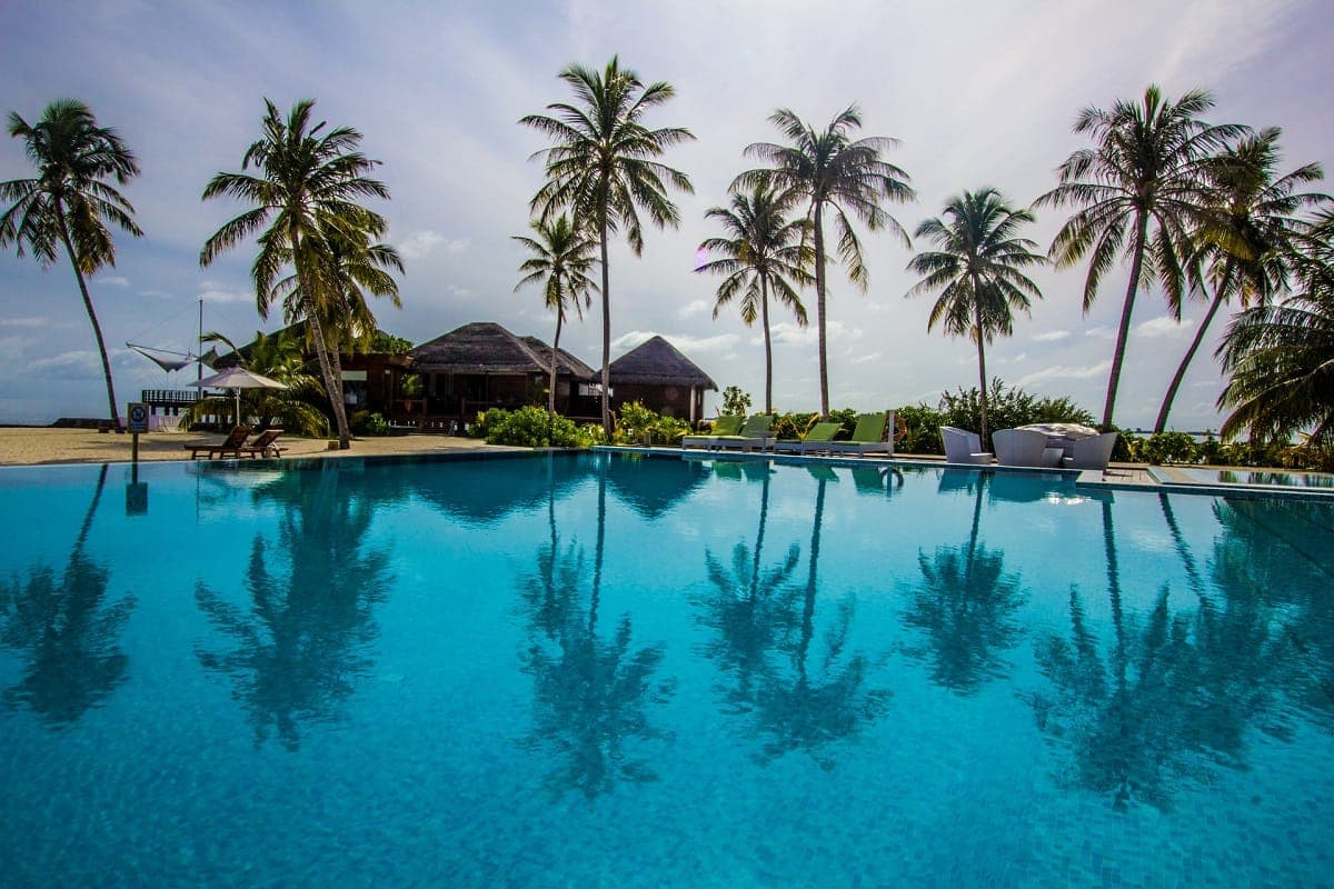 A palm-lined poolside at a Sandals resort in the Bahamas at golden hour